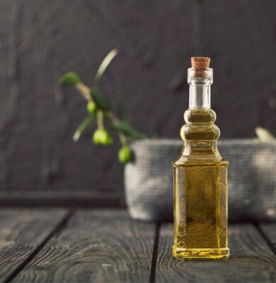 Olive oil on top of a wooden countertop.