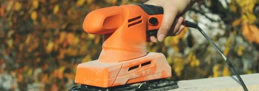 Sanding drywall with electric sander.