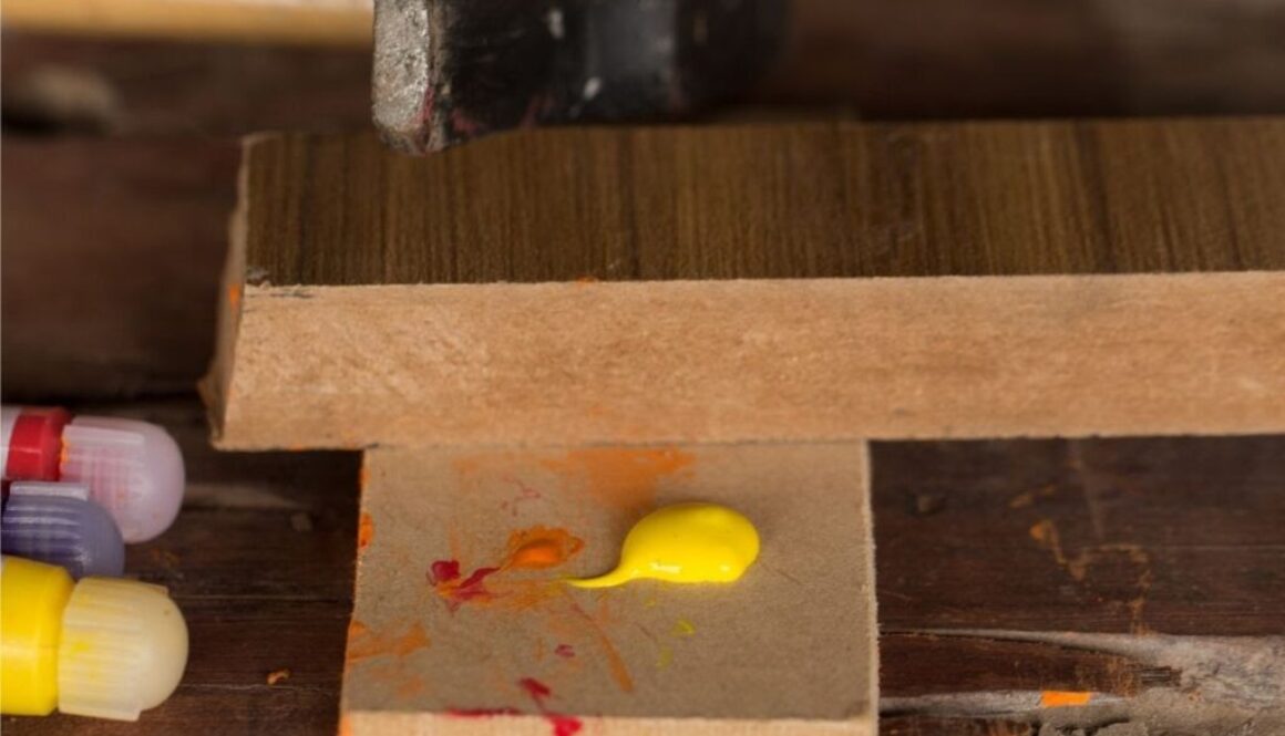 A woodworker using acrylic paint on wood.