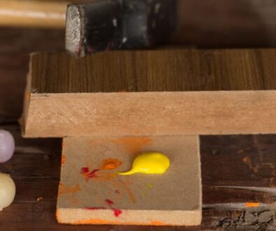 A woodworker using acrylic paint on wood.