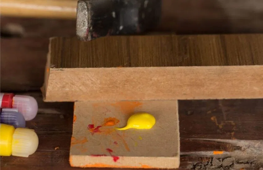 A woodworker using acrylic paint on wood.