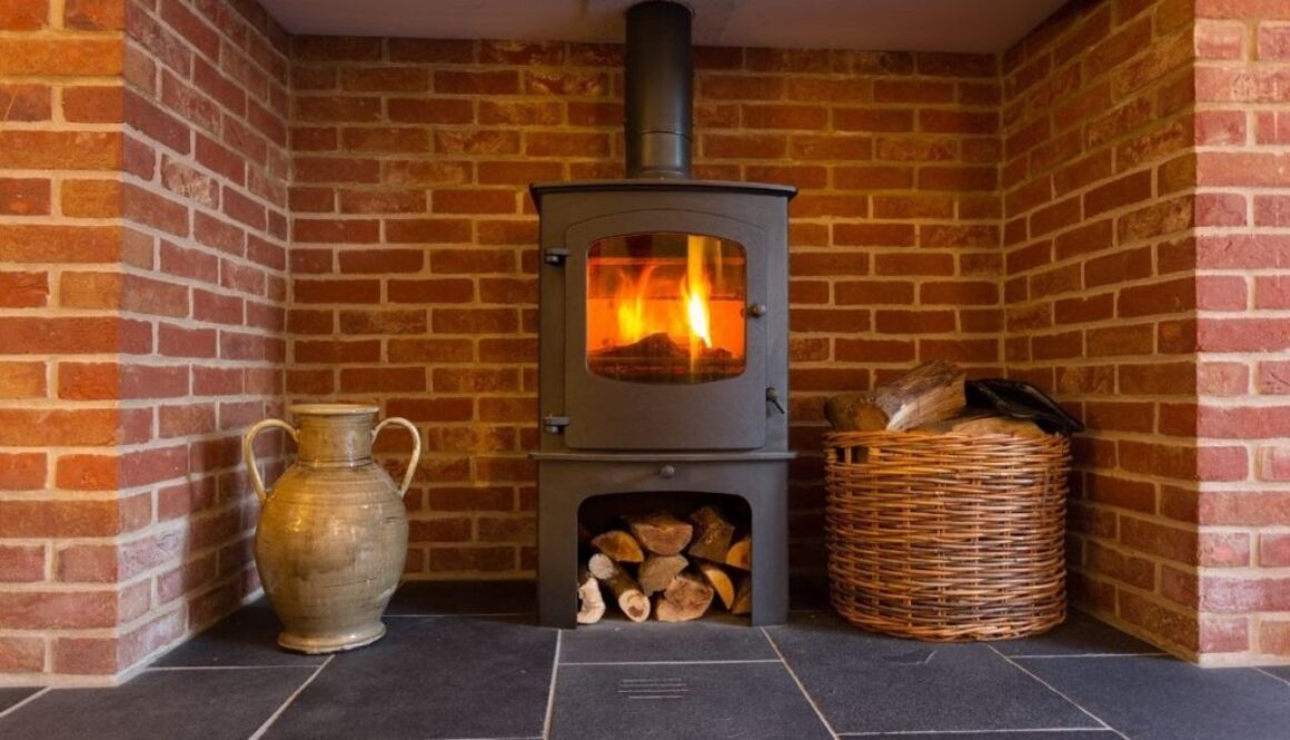 A freestanding wood stove installed in a fireplace.