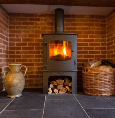 A freestanding wood stove installed in a fireplace.