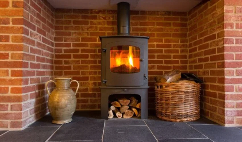 A freestanding wood stove installed in a fireplace.