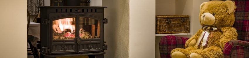 Someone installing a freestanding wood stove in a fireplace.