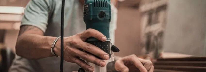 A carpenter using woodworking tools.