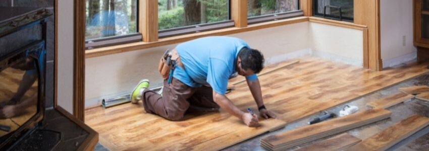 A man installing a floating wood floor.