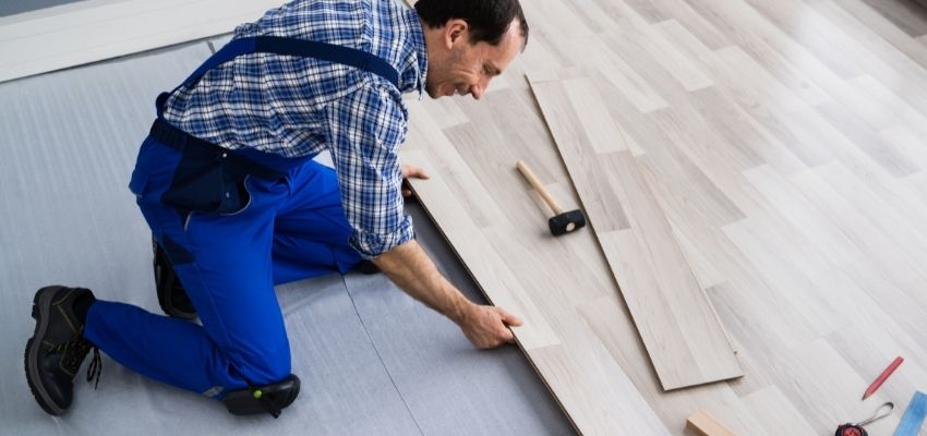 A man installing a flooring on a home.
