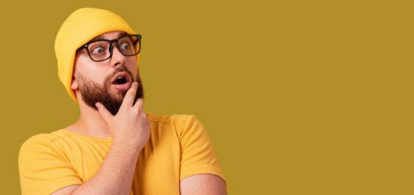 a bearded man with a yellow shirt and yellow bonnet hat wearing an eyeglass came up of an idea