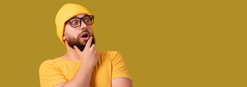 a bearded man with a yellow shirt and yellow bonnet hat wearing an eyeglass came up of an idea