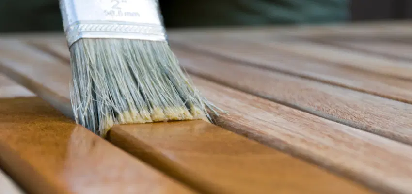 Someone applying stain to a piece of wood.