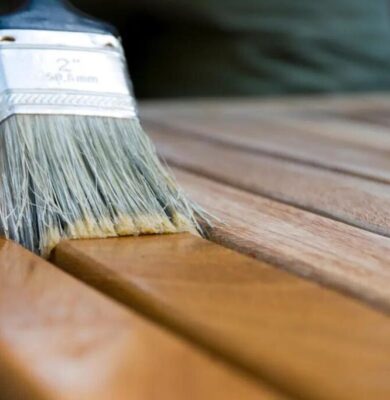 Someone applying stain to a piece of wood.