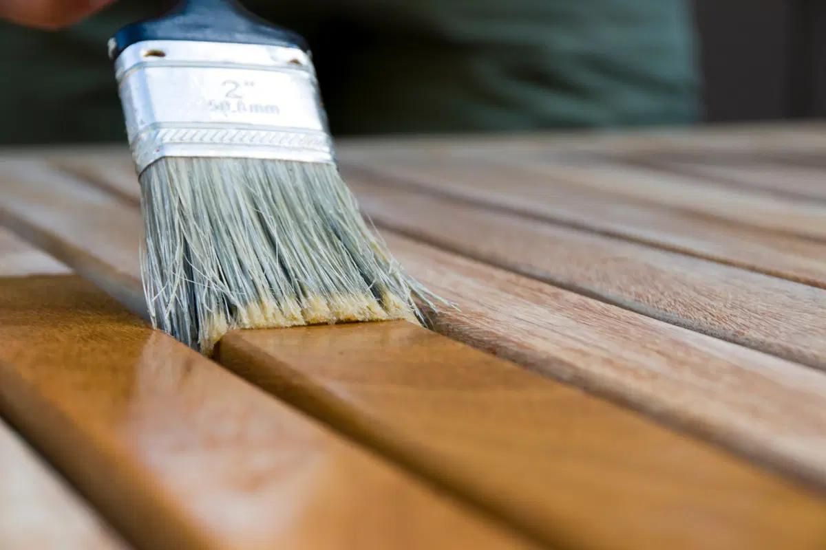 Someone applying stain to a piece of wood.