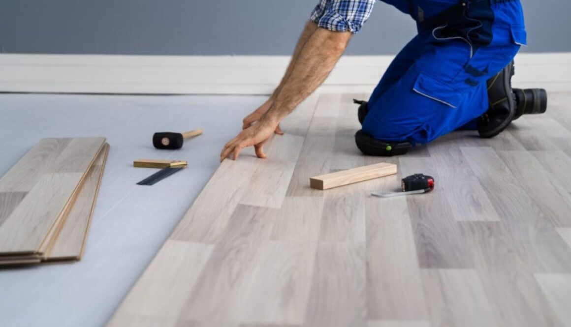 An experienced man installs and patches hardwood floors.