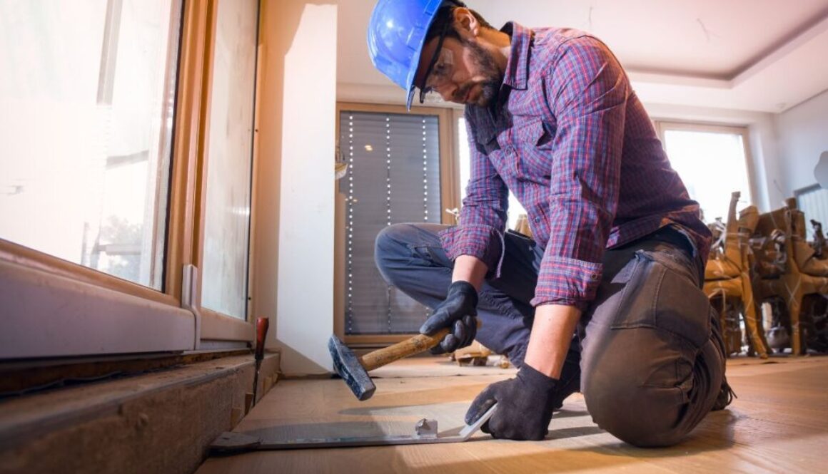 A skilled person repairs damage to a hardwood floor.