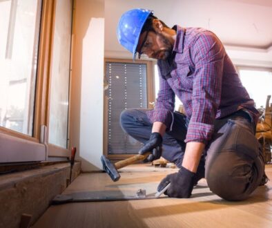 A skilled person repairs damage to a hardwood floor.