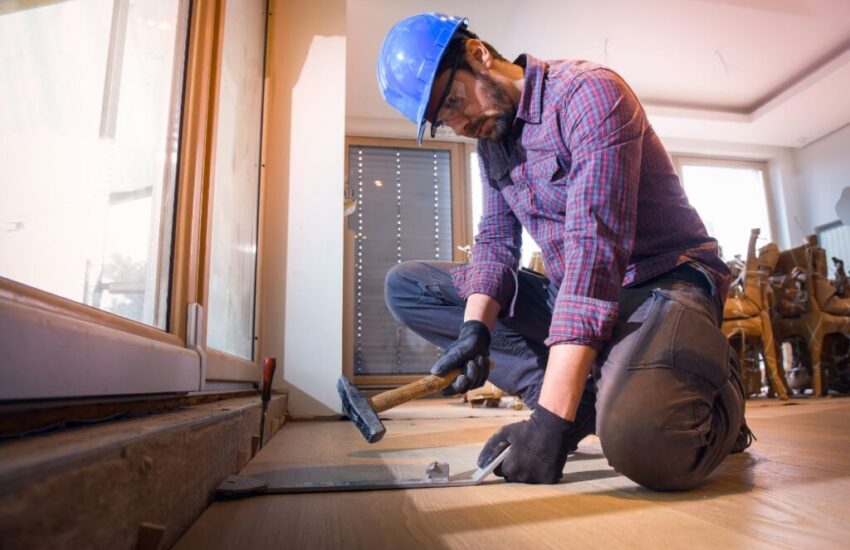A skilled person repairs damage to a hardwood floor.