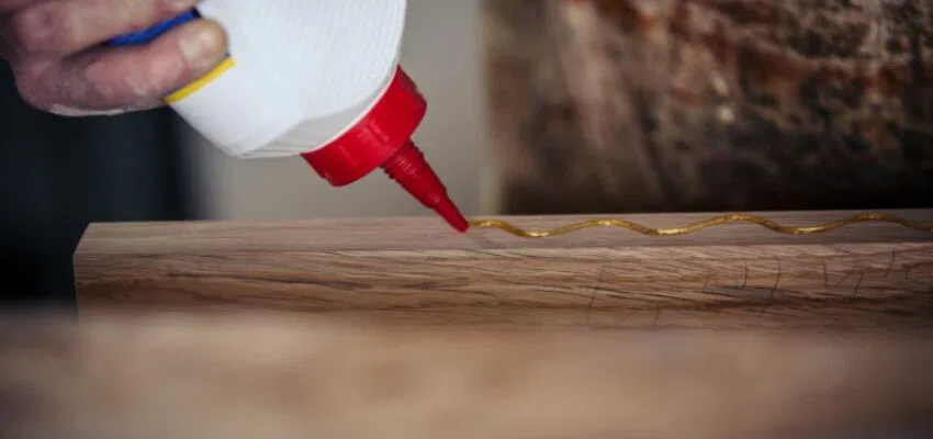 An expert using wood glue as construction adhesives.