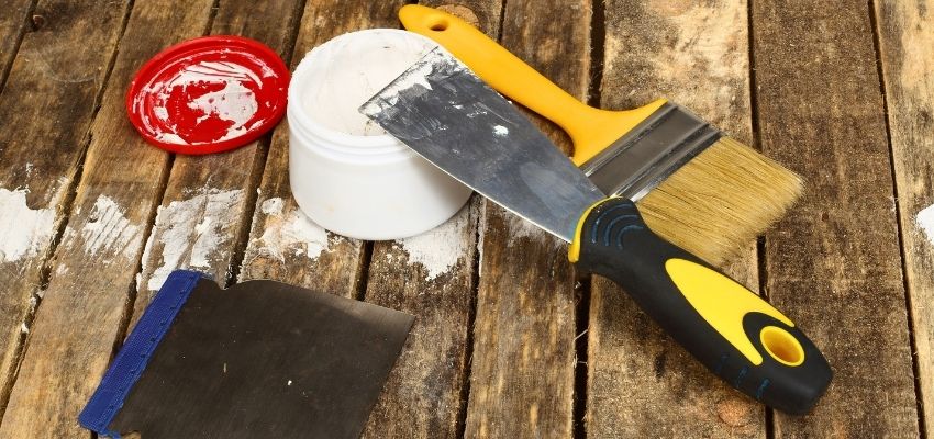 Wood putty vs wood filler tools and material displayed on a work table.