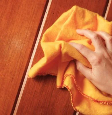 The woman tried to remove the stains from the wood.