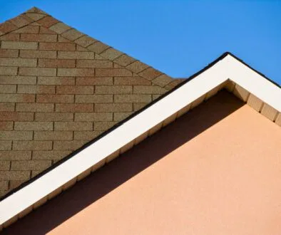 Close-up of a house roof with asphalt shingles under clear sky demonstrating the minimum roof pitch for effective water runoff.