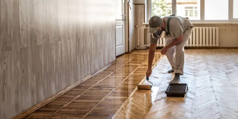 A homeowner applying the best hardwood floor polish in the US.