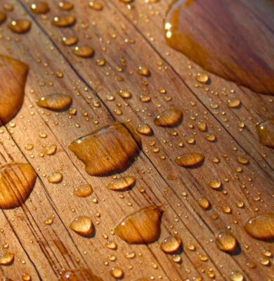 Water droplets beading on treated water resistant wood, showing effective moisture protection.