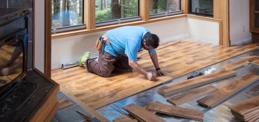 The expert ensures that the wood floor has a moisture barrier.