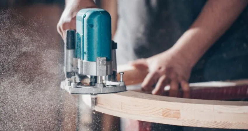 The man is using Rubberwood to create furniture.