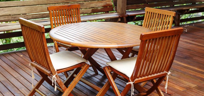 acacia-wood-vs-teak3 Teak outdoor patio set with slatted table and chairs on a wooden deck – Acacia Wood Vs Teak for outdoor furniture use.