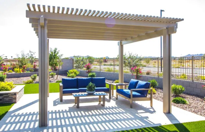 Backyard view showing a wooden pergola with a seating set, illustrating what a pergola is used for.