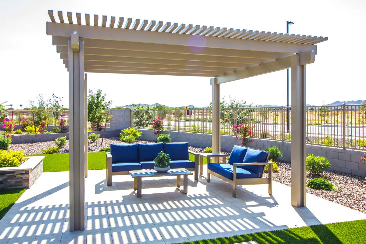 Backyard view showing a wooden pergola with a seating set, illustrating what a pergola is used for.