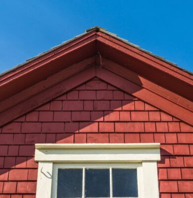 Red wooden gable roof illustrating a steep design that exceeds the minimum roof pitch.