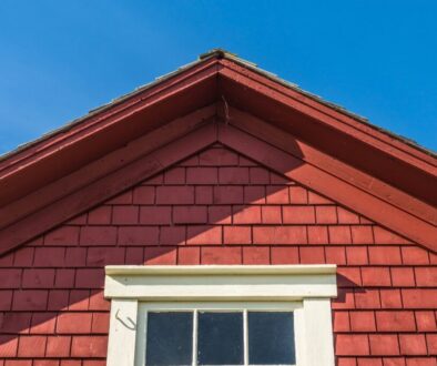 Red wooden gable roof illustrating a steep design that exceeds the minimum roof pitch.