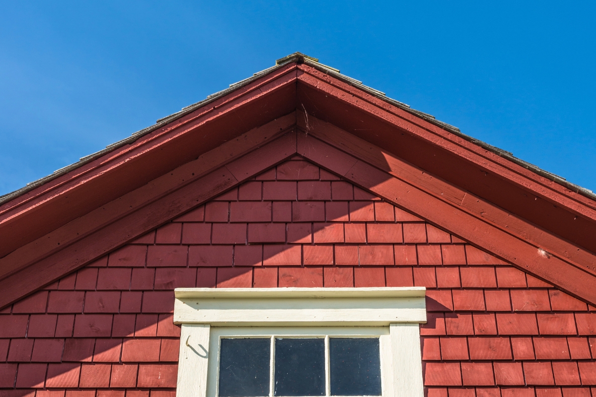 Red wooden gable roof illustrating a steep design that exceeds the minimum roof pitch.