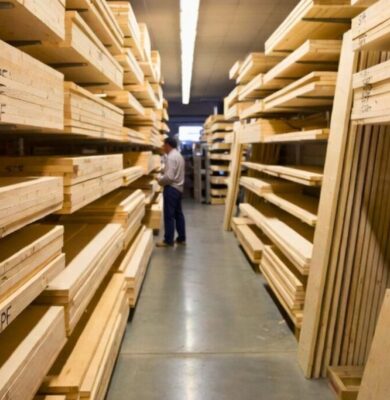 SPF wood lumber stacked in a warehouse aisle with a man inspecting the marked SPF boards