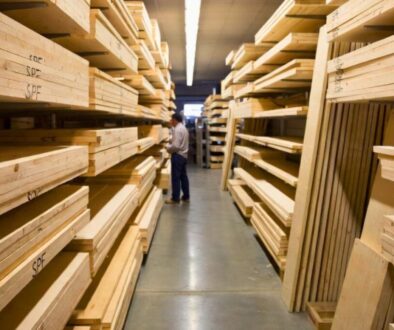 SPF wood lumber stacked in a warehouse aisle with a man inspecting the marked SPF boards