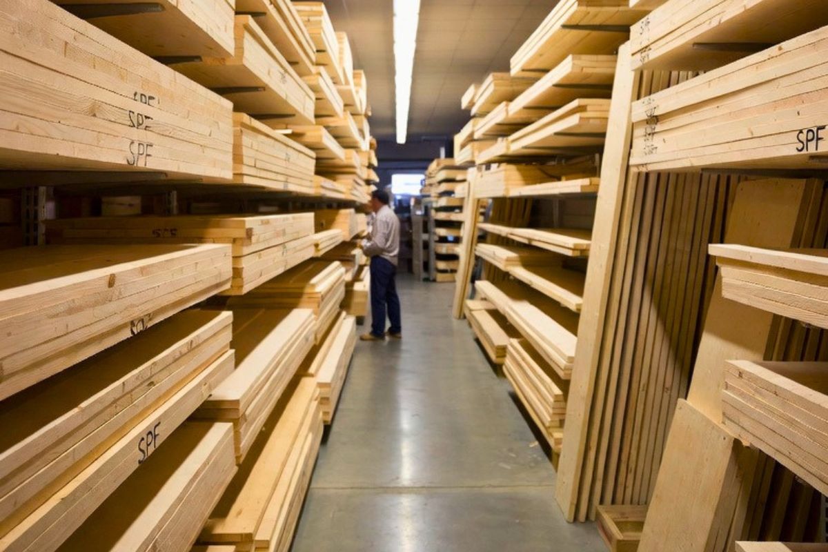 SPF wood lumber stacked in a warehouse aisle with a man inspecting the marked SPF boards