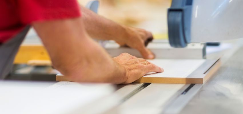 A worker cutting an engineered board to demonstrate what is composite wood in practice