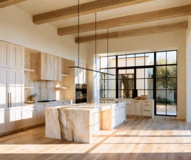 Elegant tuscan style kitchen featuring a large marble island and natural light-filled space