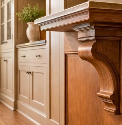 Detailed view of a wooden kitchen island supported by ornate corbels.