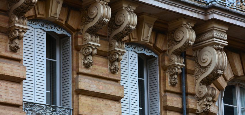 Ornate stone corbels supporting balconies on a historic building facade.